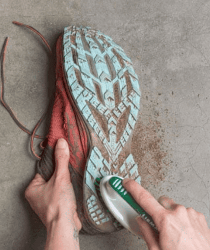 A Person Using A Soft Brush And Baking Soda To Remove Tough Stains From A Pair Of On Cloud Shoes